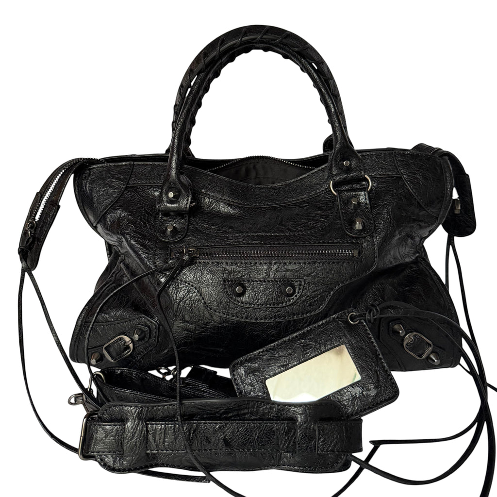 Black vegan leather city bag with braided handles and studded details.
