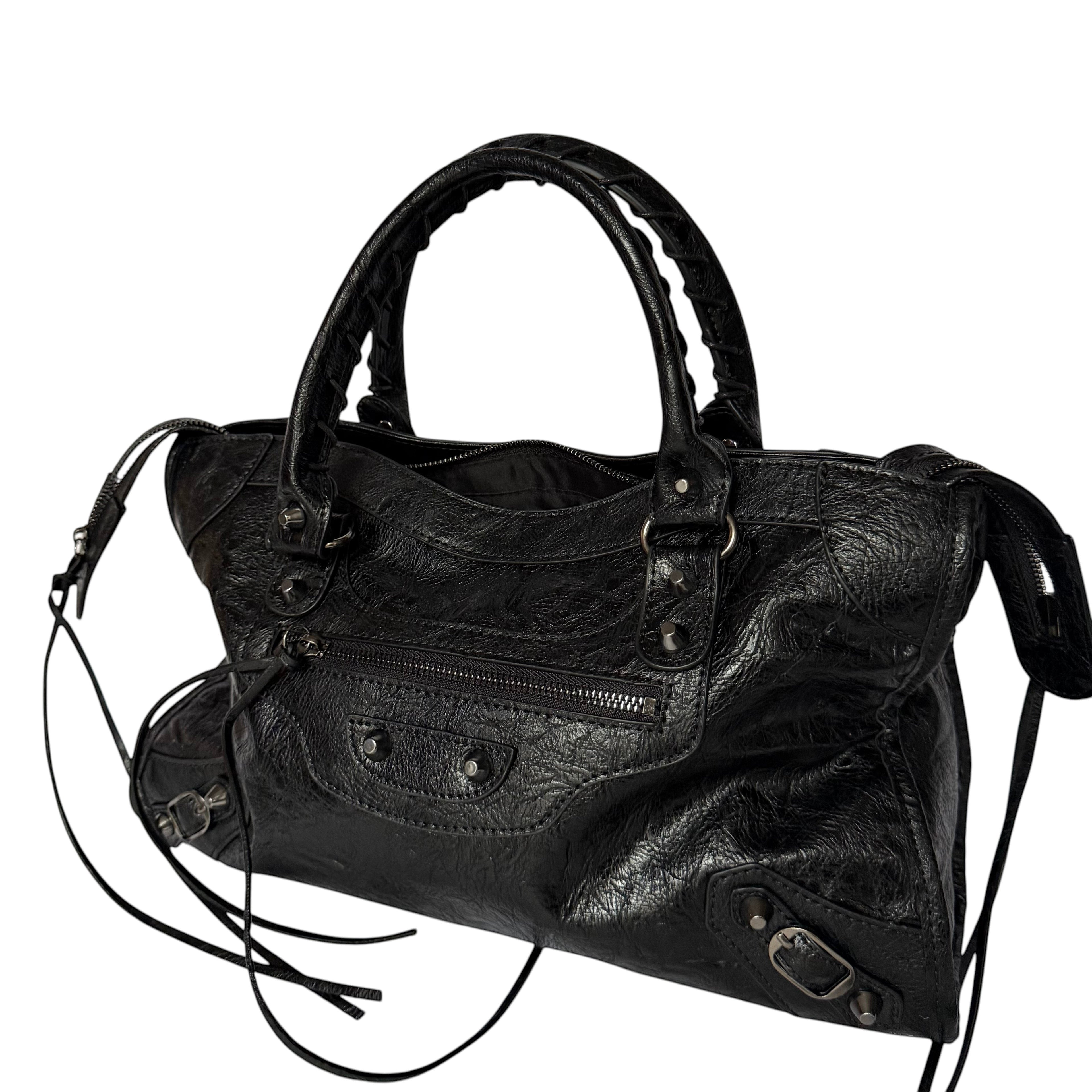 Black vegan leather city bag with braided handles and studded details.