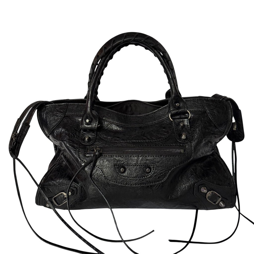 Black vegan leather city bag with braided handles and studded details.
