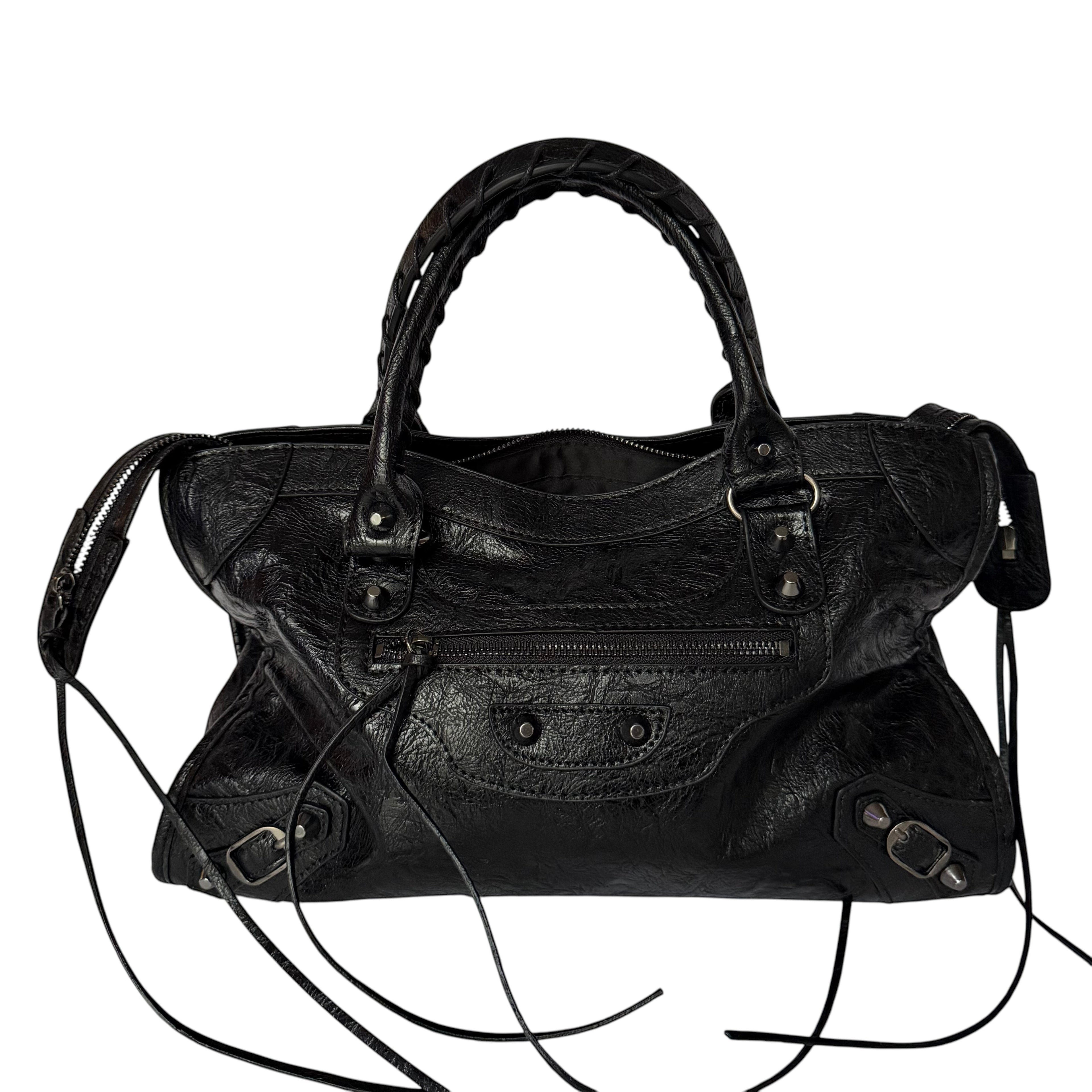 Black vegan leather city bag with braided handles and studded details.
