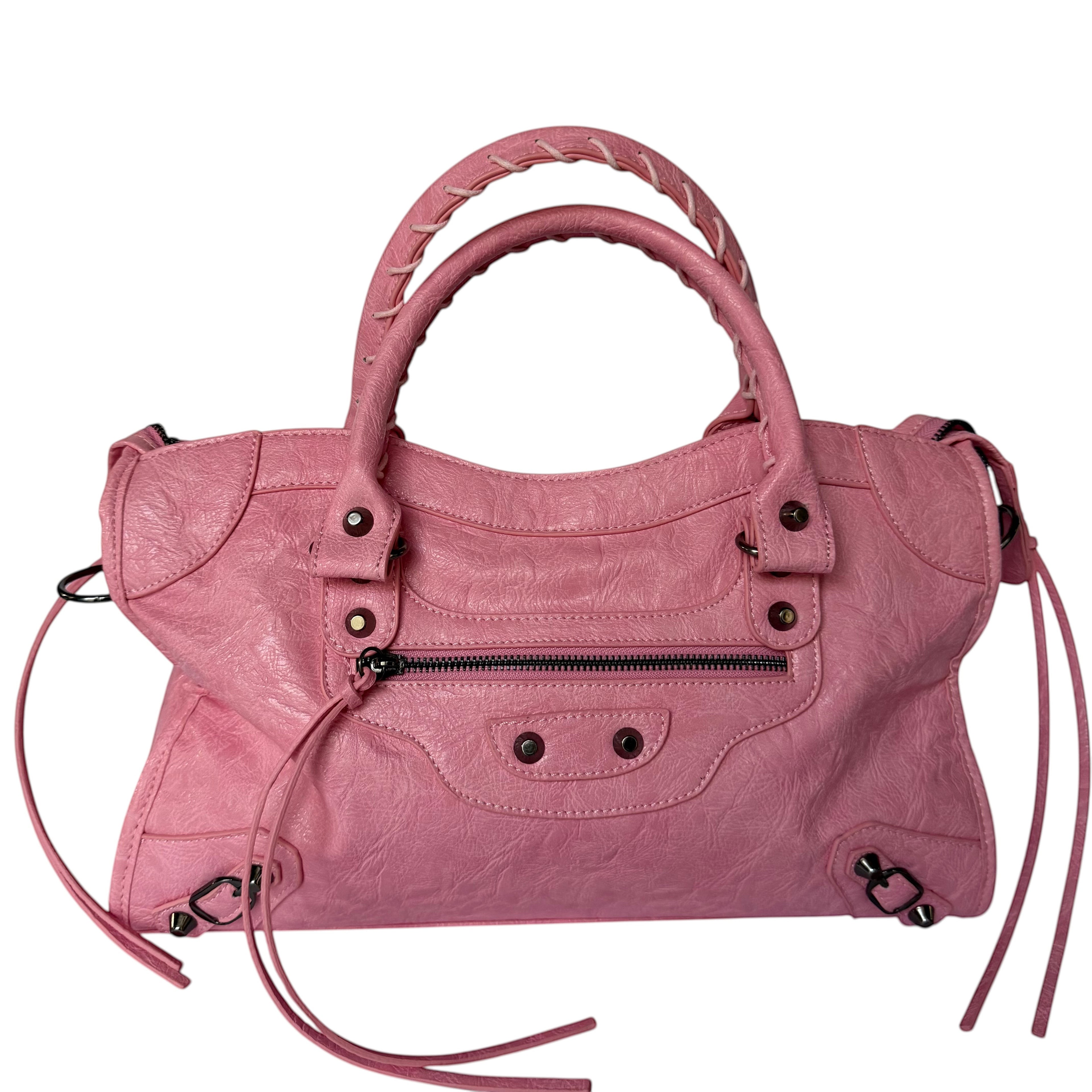 Pink vegan leather city bag with braided handles and studded details.