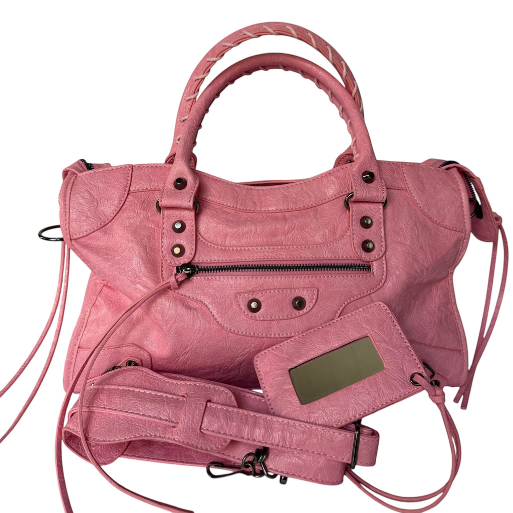 Pink vegan leather city bag with braided handles and studded details.